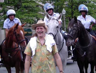 Jueri posing in front of 3 mounted police.